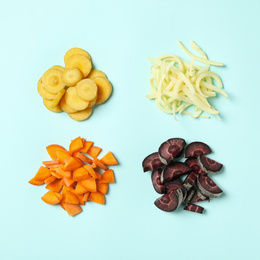 Cut raw color carrots on light blue background, flat lay