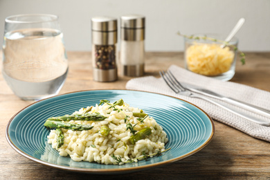 Delicious risotto with asparagus served on wooden table