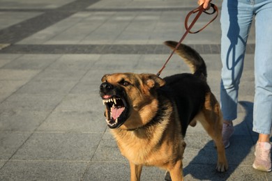Woman with her aggressive dog outdoors, closeup