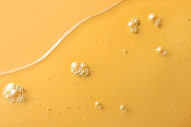 Sample of hydrophilic oil on orange background, top view