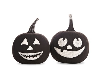 Black pumpkins with scary drawn faces on white background. Halloween celebration