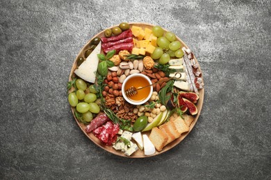 Photo of Different tasty appetizers on dark grey table, top view