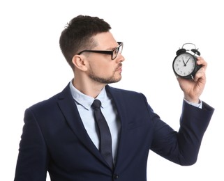 Businessman holding alarm clock on white background. Time management