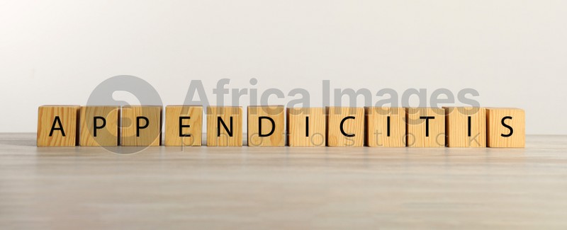 Photo of Word Appendicitis made of cubes with letters on wooden table