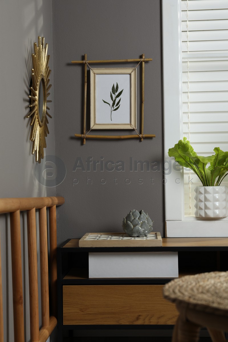 Stylish room interior with bamboo frame on grey wall