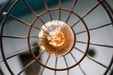 Stylish metallic pendant lamp with Edison light bulb indoors, bottom view