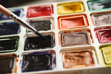 Brush and palette of watercolor paints, closeup view