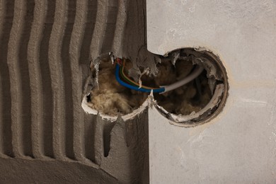 Adhesive mix, tile and socket hole with wires on wall, closeup. Space for text