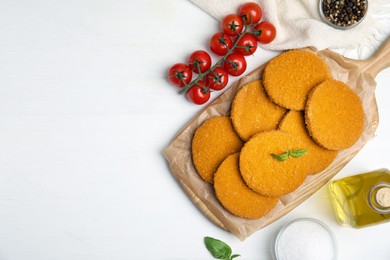 Photo of Delicious fried breaded cutlets served on white table, flat lay. Space for text