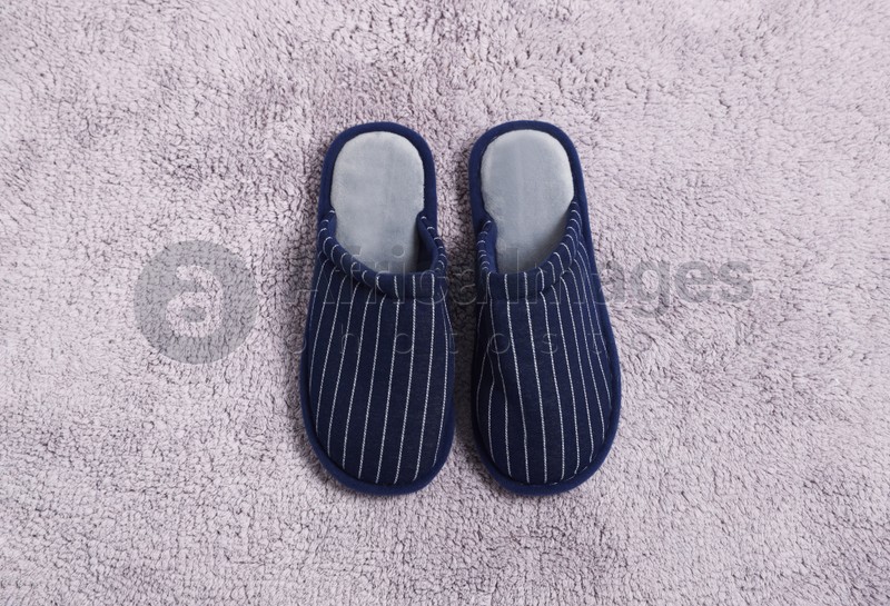 Photo of Pair of stylish slippers on light grey carpet, top view