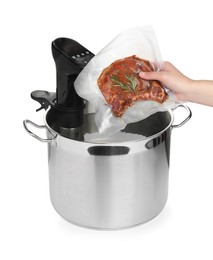Woman putting vacuum packed meat in pot with sous vide cooker on white background, closeup