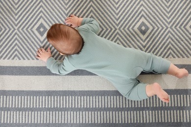 Cute baby crawling on floor, top view