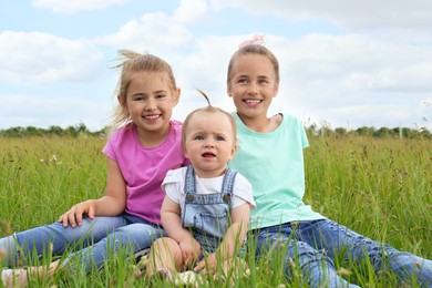 Cute happy girls on green grass in field