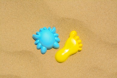 Colorful plastic molds on sand, flat lay. Beach toys