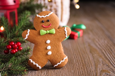 Photo of Gingerbread man on wooden table, closeup view
