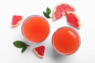 Tasty freshly made grapefruit juice and fruits on white background, top view