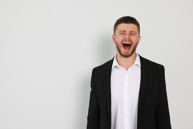 Aggressive young man shouting on white background, space for text