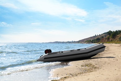 Inflatable rubber fishing boat on sandy beach near sea