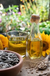 Photo of Sunflower oil and seeds on wooden table outdoors