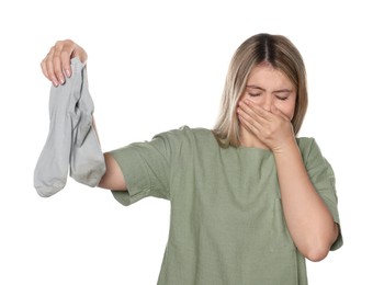 Photo of Young woman feeling bad smell from dirty socks isolated on white
