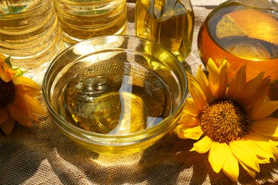 Photo of Organic sunflower oil and flowers on fabric, closeup