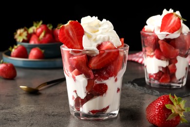 Delicious strawberries with whipped cream served on grey table