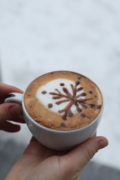 Photo of Woman with cup of aromatic coffee outdoors in winter, closeup
