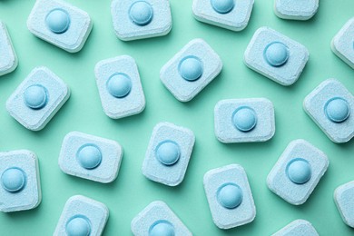 Photo of Water softener tablets on turquoise background, flat lay