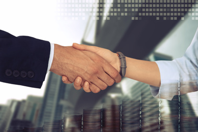 Image of Multiple exposure of partners shaking hands, coins and city. Business values