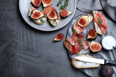 Sandwiches with ripe figs, cream cheese and prosciutto served on black table, flat lay. Space for text