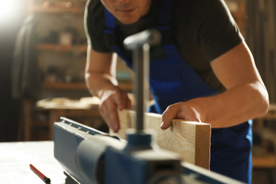 Professional carpenter working with wood in shop, closeup