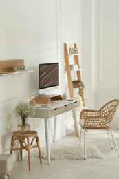 Comfortable workplace with modern computer and lamp in room. Interior design
