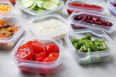 Set of containers with fresh food on white table