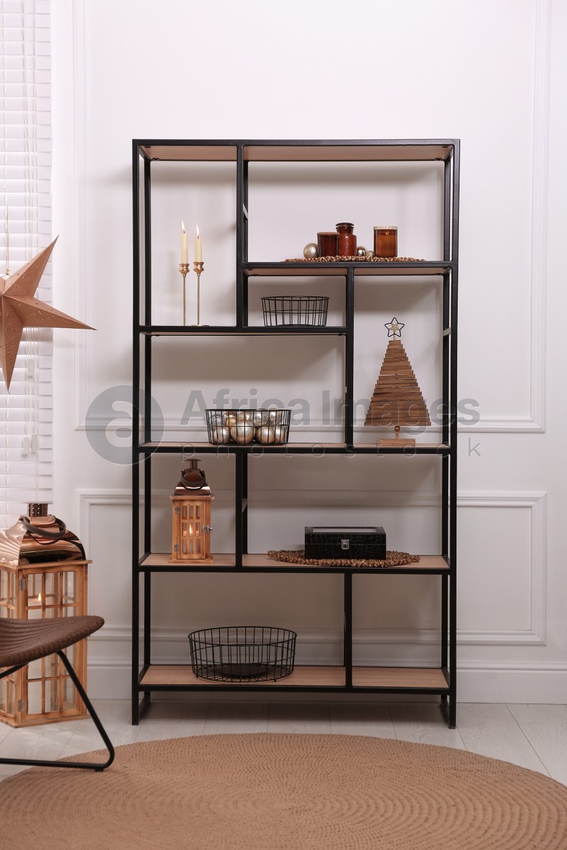 Photo of Stylish shelving unit with different decor near white wall indoors. Interior design