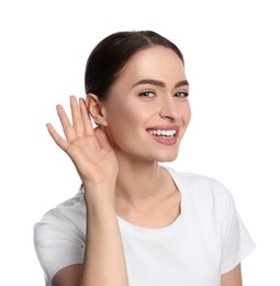 Young woman showing hand to ear gesture on white background