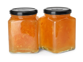 Delicious orange marmalade in jars on white background