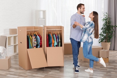 Young couple dancing near wardrobe boxes at home