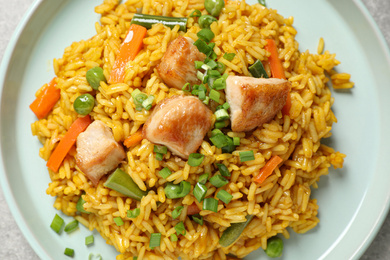 Delicious rice pilaf with chicken and vegetables in plate, closeup