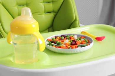 Baby high chair with healthy food and water, closeup view