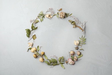 Dried flowers and leaves arranged in shape of wreath on light grey background, flat lay with space for text. Autumnal aesthetic