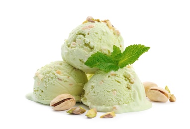 Scoops of delicious pistachio ice cream with mint and nuts on white background