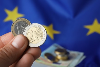 Woman holding coins near European Union flag, closeup. Space for text