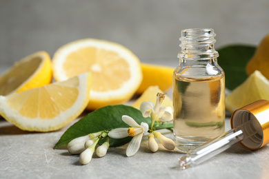 Citrus essential oil, flower and lemons on light table
