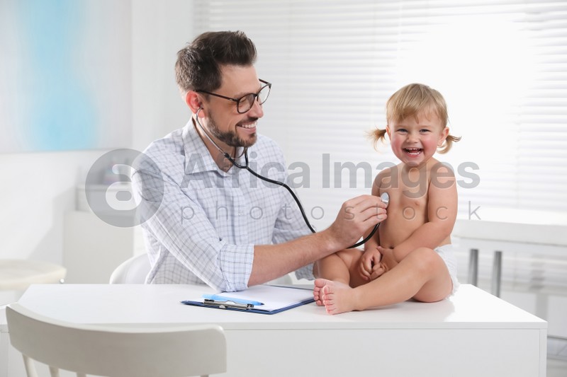 Photo of Pediatrician examining baby with stethoscope in clinic