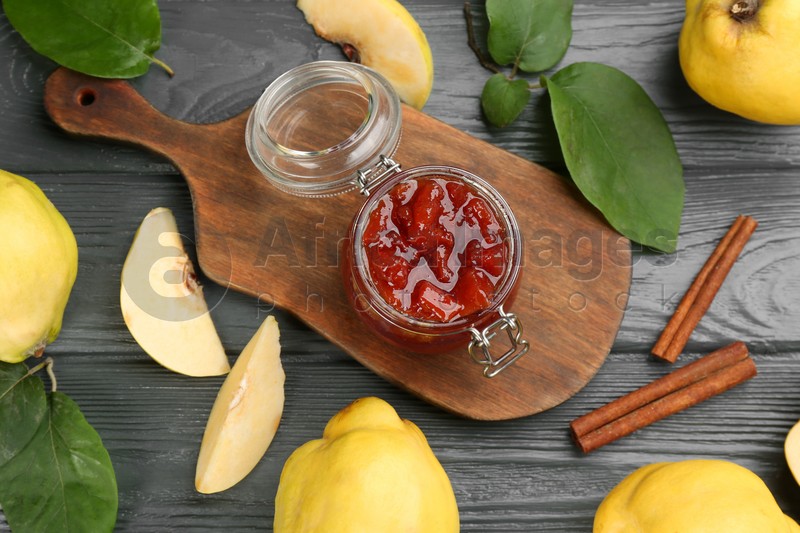 Photo of Delicious quince jam and fruits on grey wooden table, flat lay