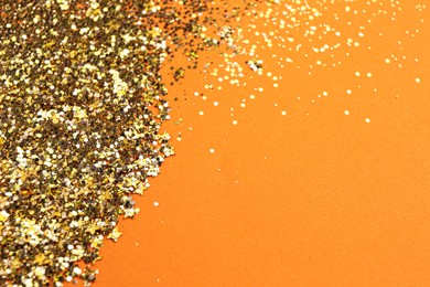 Shiny bright golden glitter on pale coral background. Space for text