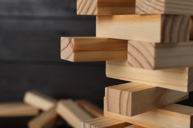 Jenga tower made of wooden blocks on blurred background, closeup