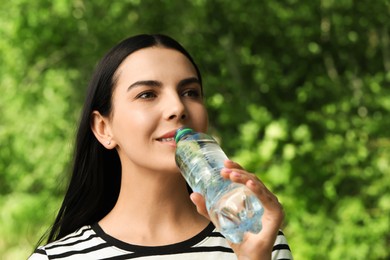 Young woman drinking water outdoors. Refreshing drink