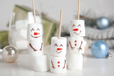 Funny snowmen made of marshmallows on white table