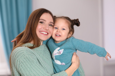 Photo of Young mother with little daughter at home